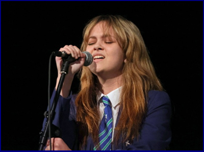 Year 11 student with a microphone singing